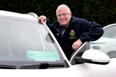 John Farrow, ACS Driver next to a car